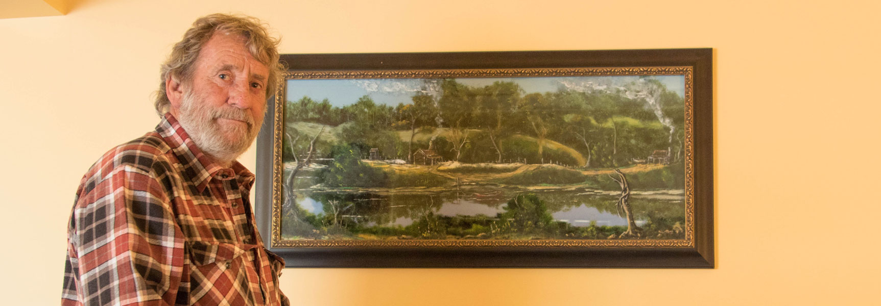 Artist Craig 'Bushie' Williams with oil on glass artwork